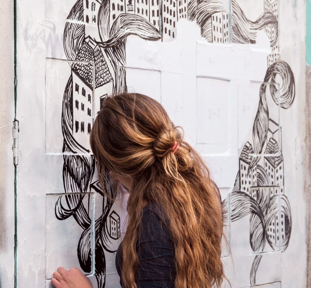 Malasaña neighbourhood in Madrid - girl painting on wall